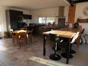a kitchen with a wooden table and some chairs at La Grange Du Bosquet in Honnecourt-sur-lʼEscaut