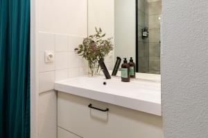 a bathroom with a white sink and a mirror at DIFY Eugene - Part Dieu in Lyon