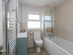 a bathroom with a toilet and a sink and a window at Mermaid House in Weymouth +33 photos