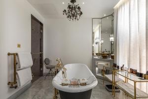 a bath room with a tub and a chair at The Mandrake in London