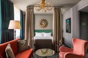 una camera d'albergo con letto e lampadario a braccio di The Mandrake a Londra
