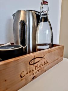 a wooden tray with a bottle of water and a kettle at Casa Mafalda in Chioggia
