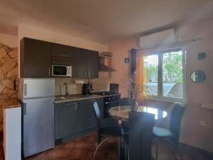 eine Küche mit einem weißen Kühlschrank und einem Tisch mit Stühlen in der Unterkunft Apartmani M&C in Fažana