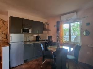 a kitchen with a white refrigerator and a table with chairs at Apartmani M&C in Fažana