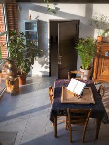 una mesa y sillas en una habitación con plantas en La Grange Du Bosquet, en Honnecourt-sur-lʼEscaut