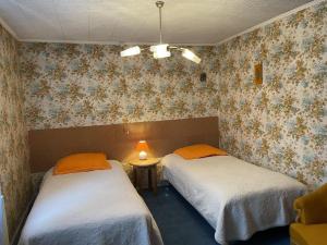 2 Betten in einem Zimmer mit Blumentapete in der Unterkunft Gîte Arfeuilles, 4 pièces, 6 personnes - FR-1-489-277 in Arfeuilles