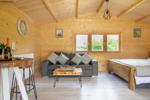 un soggiorno con divano e letto di Choller Lake Lodges - Primrose Cabin With Private Hot Tub ad Arundel