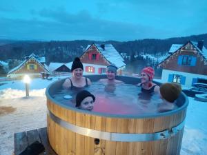 - un groupe de personnes dans un bain à remous dans la neige dans l'établissement Kolorowe Karkonosze, à Przesieka