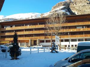 a large building with snow covered mountains in the background at Appartement Valloire, 2 pièces, 5 personnes - FR-1-263-456 in Valloire