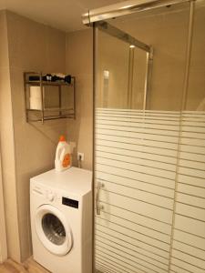 uma casa de banho com uma máquina de lavar roupa e uma cabina de duche em vidro. em The BEST Views in Alcúdia - 7th floor studio em Alcudia