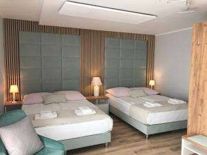 Un dormitorio con dos camas y una silla. en Villa Magda, en Ustronie Morskie