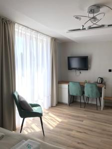 Una habitación con dos sillas y un escritorio y un televisor. en Villa Magda, en Ustronie Morskie