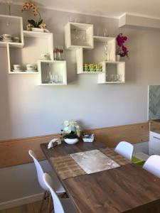 Un comedor con una mesa de madera y sillas blancas. en Villa Magda, en Ustronie Morskie 38 fotos más