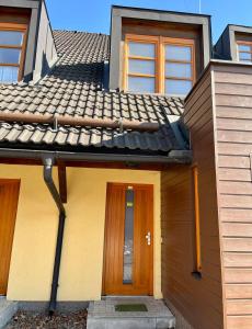 una casa con una porta in legno e un tetto di Apartmán u Tesáka - Říčky v Orlických horách a Říčky
