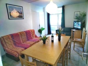 una sala de estar con una mesa y un sofá en Résidence du parc des Tilleuls de Lyon 82 m2 Pkg free, en Lyon