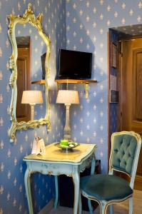 Cette chambre comprend une table, un miroir et une chaise. dans l'établissement Hotel Villa San Lorenzo Maria, à Rome