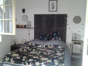 a bedroom with a bed with a large wooden headboard at Appartement indépendant au coeur du Vignoble in Prayssac