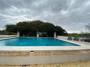 a large swimming pool on top of a house at Hortas de Baixo in Luz de Tavira +11 photos