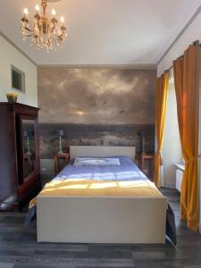 ein Schlafzimmer mit einem Bett und einem Wandgemälde in der Unterkunft Le Chateau de Claids in Saint-Patrice-de-Claids
