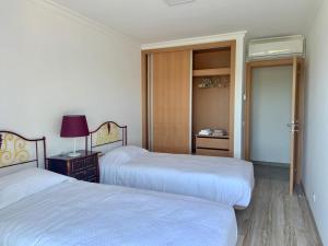 sypialnia z 2 łóżkami i drzwiami do szafy w obiekcie Hortas de Baixo w mieście Luz de Tavira
