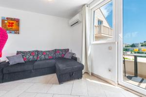 a living room with a couch and a balcony at Apartments Maria in Dubrovnik