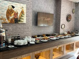 a buffet with many plates of food on a table at Hotel Ishonch in Samarkand