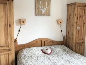 ein Schlafzimmer mit einem Bett mit einem Herzkissen drauf in der Unterkunft Chalet La Joue du Loup, 3 pièces, 7 personnes - FR-1-504-70 in Le Dévoluy