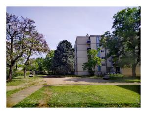 un edificio en medio de un parque con árboles en Résidence du parc des Tilleuls de Lyon 82 m2 Pkg free, en Lyon