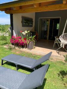a patio with a bench and a table and flowers at El Habar de Pria in La Pesa