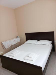 ヴロラにあるLungomare Apartament Sea view KORALの大型ベッド(白いシーツ、白い枕付)