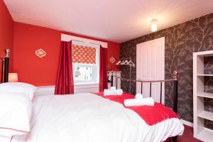 a red bedroom with a white bed and a window at The Auld Sweetie Shop in Perth