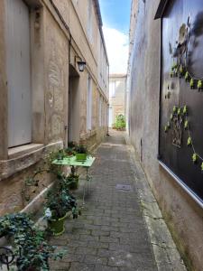 an alley with a table and potted plants on it at Le Studio 64 in Rochefort