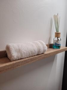 a wooden shelf with a towel and a vase on it at Le Studio 64 in Rochefort