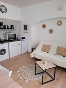 een woonkamer met een witte bank en een tafel bij Le Studio 64 in Rochefort