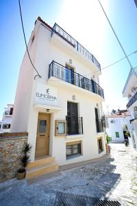 a large white building with a sign on it at Eumorphia Studios & Apartments in Skiathos