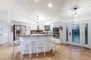 a kitchen with white cabinets and a island with bar stools at Panoramic View in Maynardville