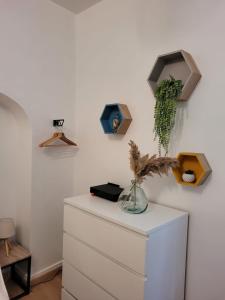 a white dresser with a vase on top of it at Le Studio 64 in Rochefort