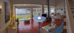 a living room with a table and a large window at Casa Beira Mar in Mosteiros