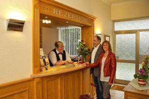 a group of people standing at a reception desk at Hotel & Restaurant Kaiserhof in Bad Bellingen