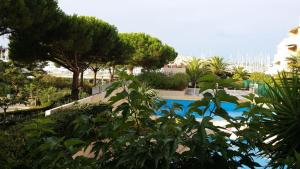 a view of a swimming pool with trees and bushes at La Voile D' Or seul hôtel sur le port in Cap d'Agde