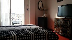 a bedroom with a bed and a flat screen tv at La Voile D' Or seul hôtel sur le port in Cap d'Agde +30 photos