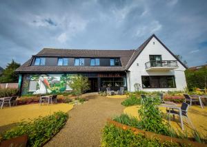 ein Gebäude mit einem Tisch und Stühlen davor in der Unterkunft Hotel Auberge St. Pol in Knokke-Heist