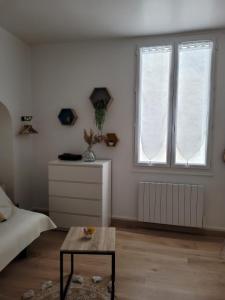 a white room with two windows and a table at Le Studio 64 in Rochefort