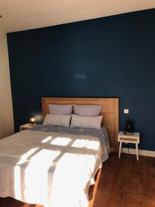um quarto com uma cama grande e uma parede azul em Un paradis de verdure en plein centre ville em Périgueux