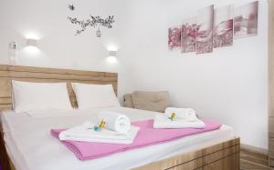 a bedroom with two beds with towels on them at 3SSS Bouquet Studios in Marmari
