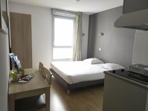 Kleines Zimmer mit einem Bett und einer Küche in der Unterkunft Lagrange Apart'Hotel l’Escale Marine in La Rochelle