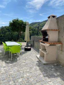 um pátio com uma mesa e um forno exterior em Cantinho Verde T3 no Gerês
