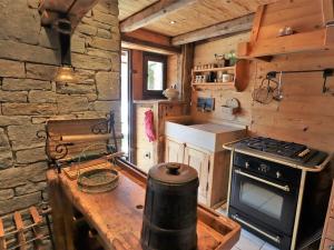 a kitchen with a stove and a stone wall at Chalet Arêches-Beaufort, 4 pièces, 6 personnes - FR-1-342-158 in Beaufort