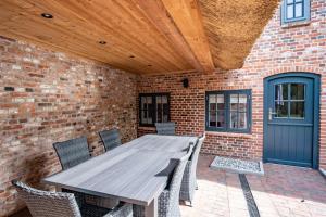 a wooden table and chairs on a patio at Dünenkate Dünenkate in Sankt Peter-Ording