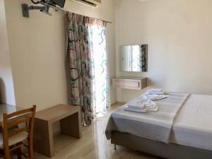 A bed or beds in a room at Angelica Studios and Apartments